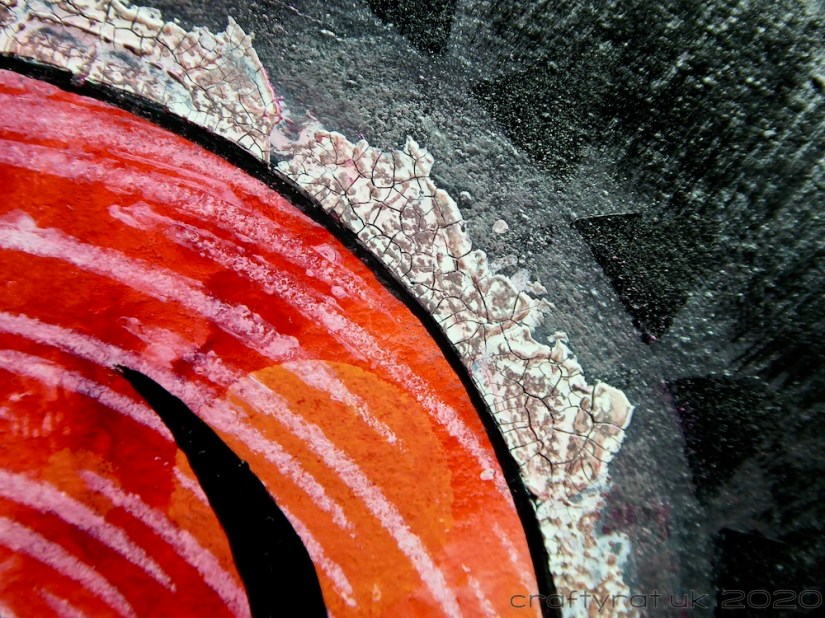 Close-up of the crackle paste edging on the red part of the infinity symbol.