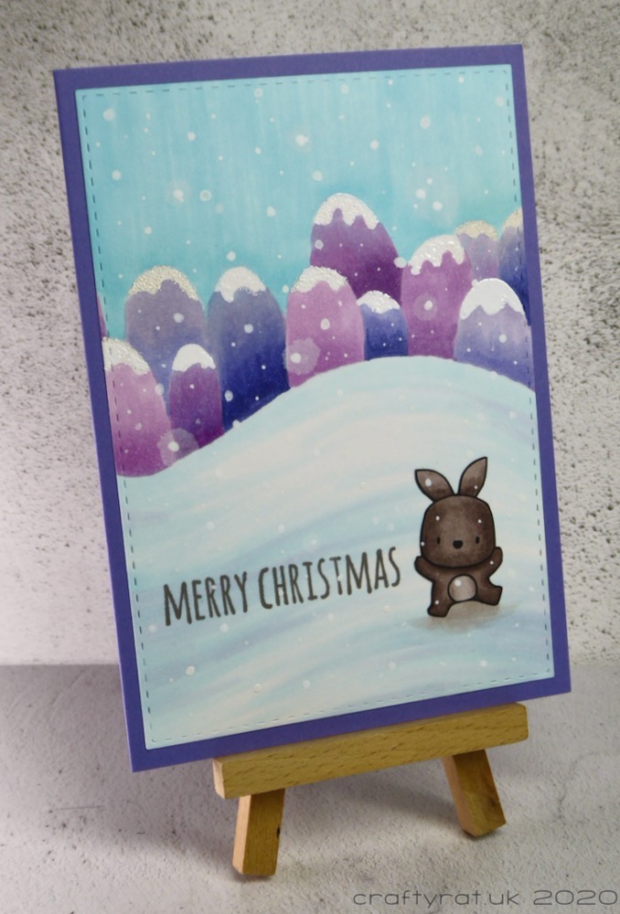 The Christmas card displayed on a small wooden easel.