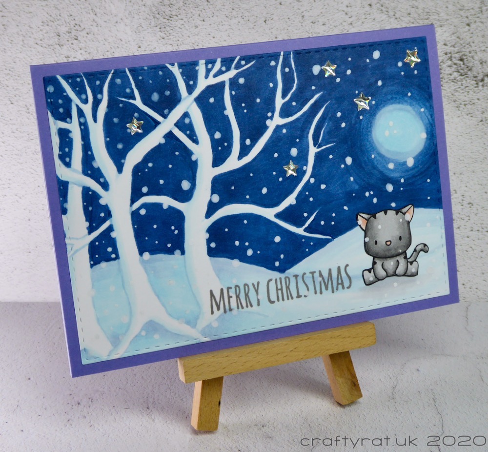 The Christmas card displayed on a small wooden easel.