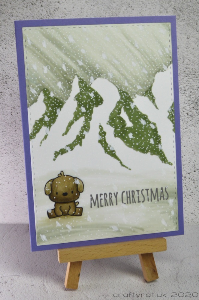 The Christmas card displayed on a small wooden easel.