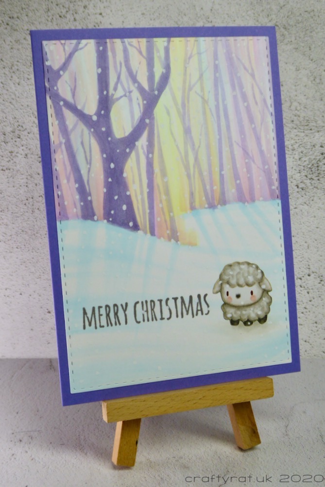 The Christmas card displayed on a small wooden easel.