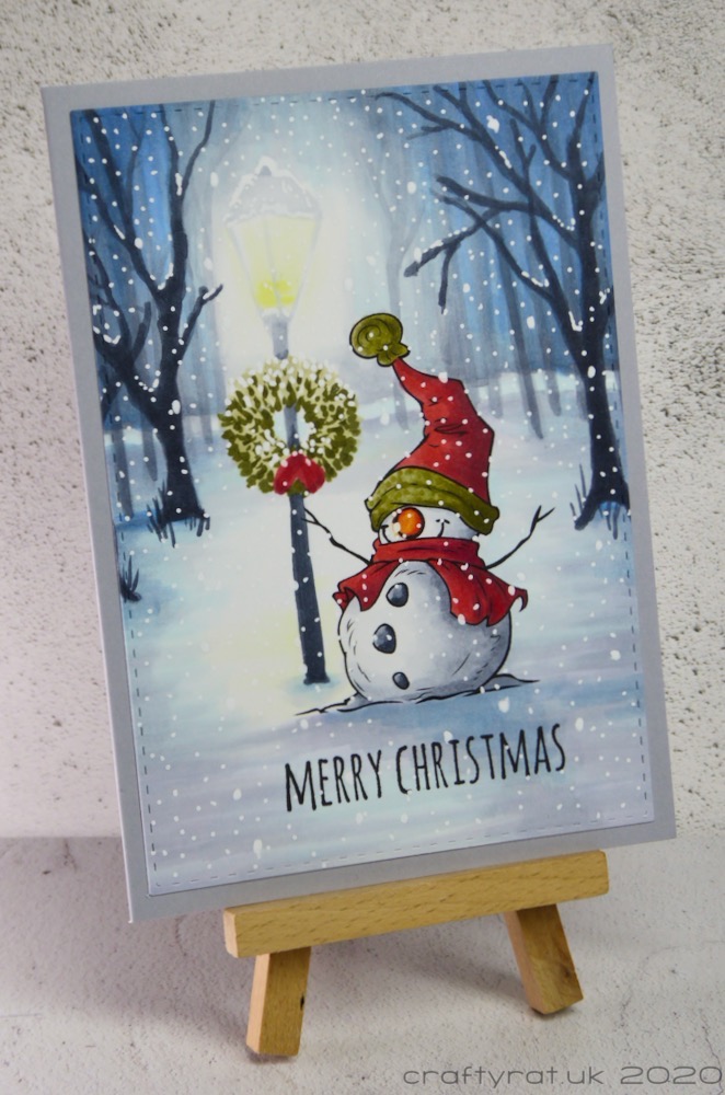 The Christmas card displayed on a small wooden easel.