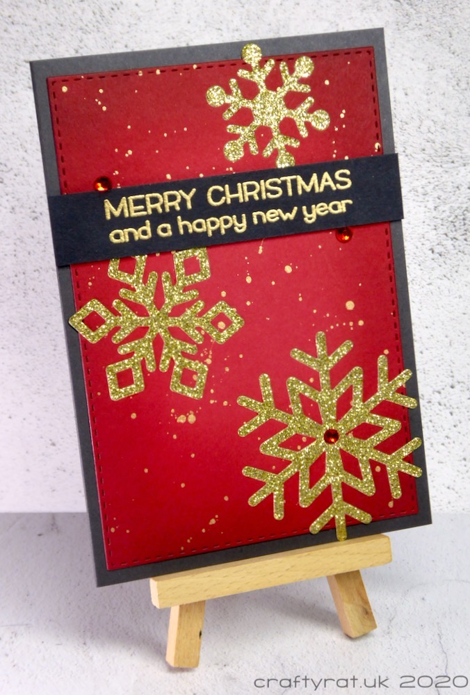 The Christmas card displayed on a mini wooden easel.