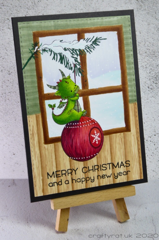 The Christmas card displayed on a small wooden easel.