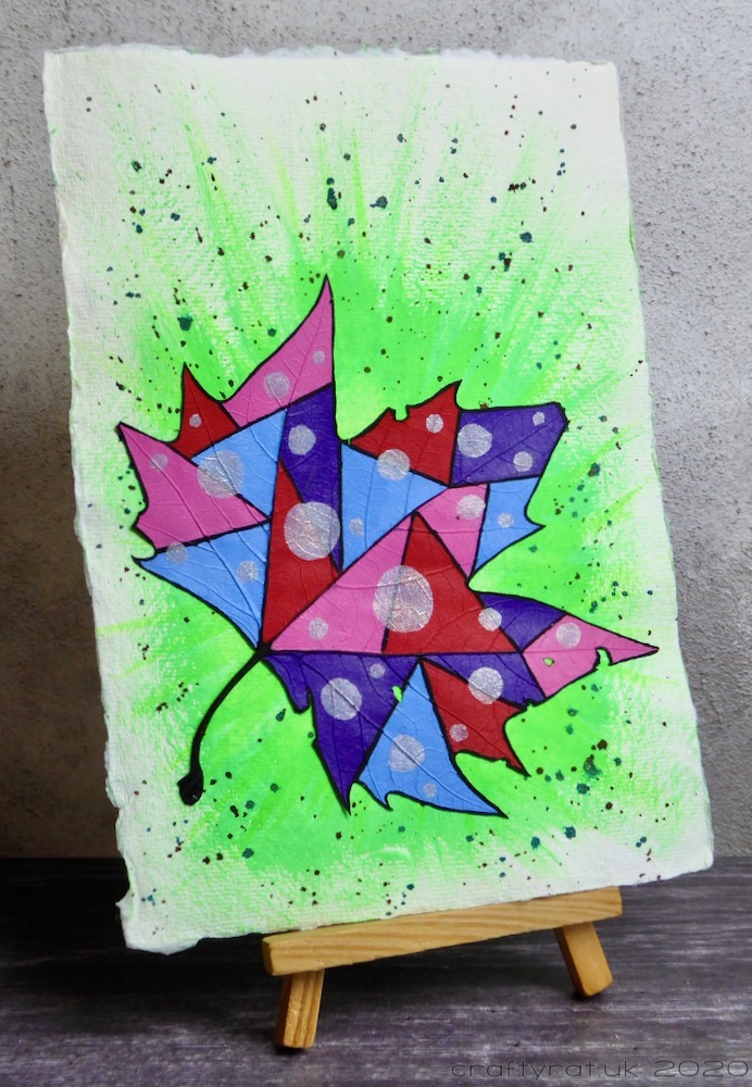 The patchwork leaf displayed on a small wooden easel.