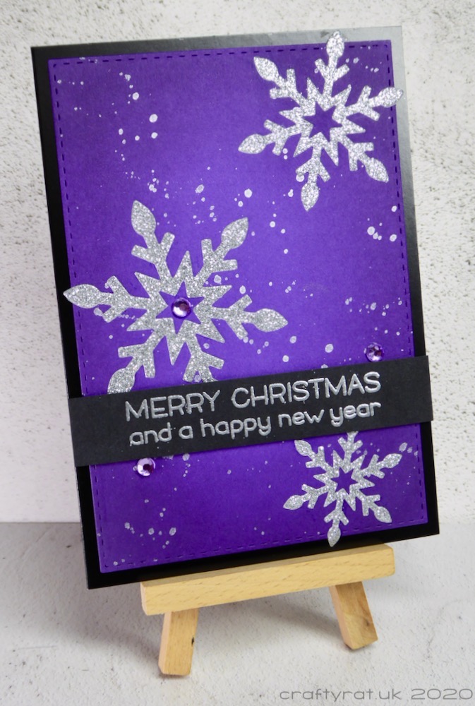 The Christmas card displayed on a small wooden easel.