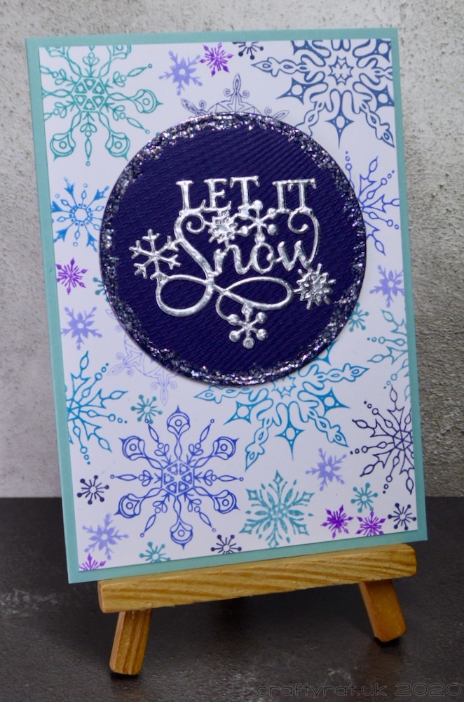 The Christmas card displayed on a small wooden easel.