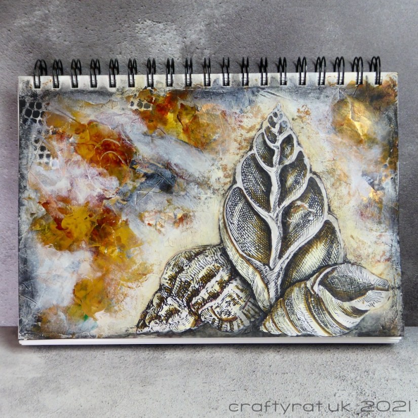 An art journal page with three illustrated shells on a background of neutral colours with touches of gold.