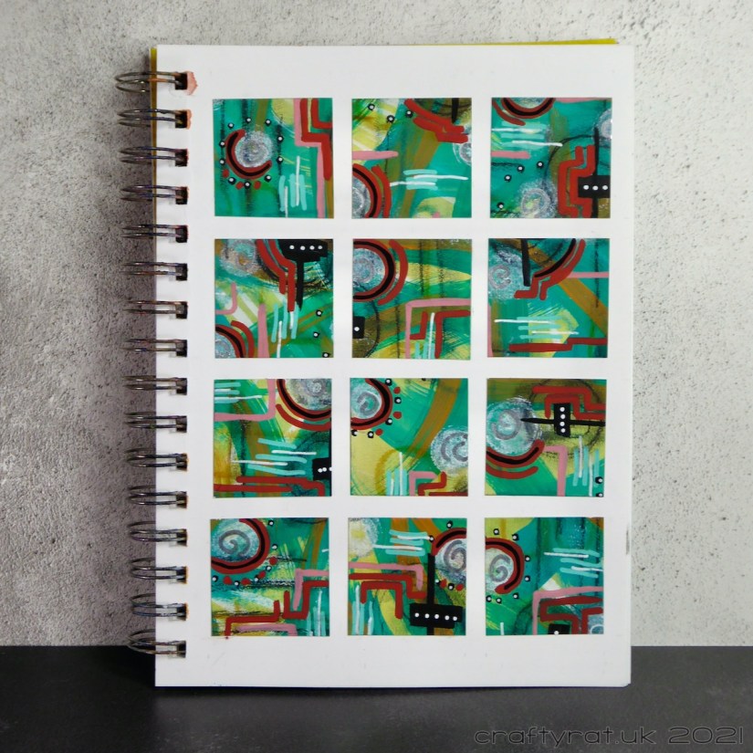 Art journal page with a grid of twelve squares cut from a page of paint swipes and mark-making.