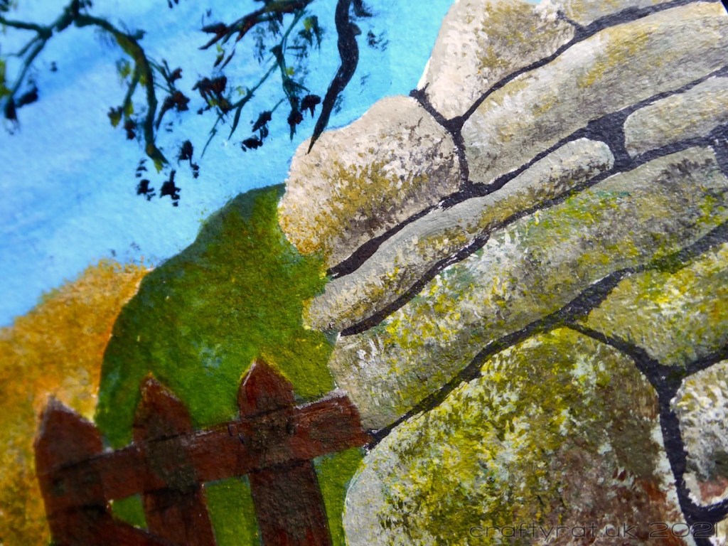 A close-up of the dry stone wall and the view through the gate.